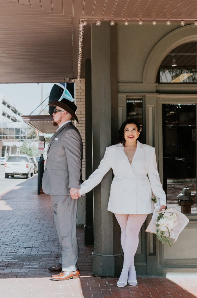 Newlyweds embracing in front of the Tarrant County Courthouse in Downtown Fort Worth