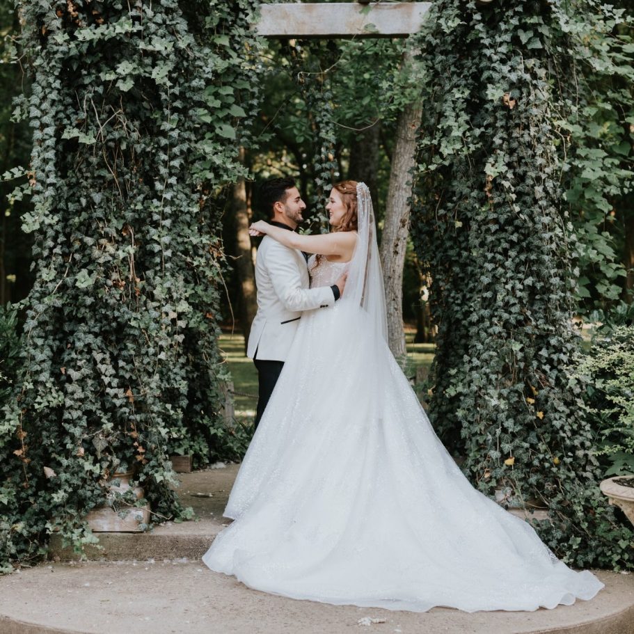 Bride and groom embracing beside the fountain at The Milestone Mansion Aubrey