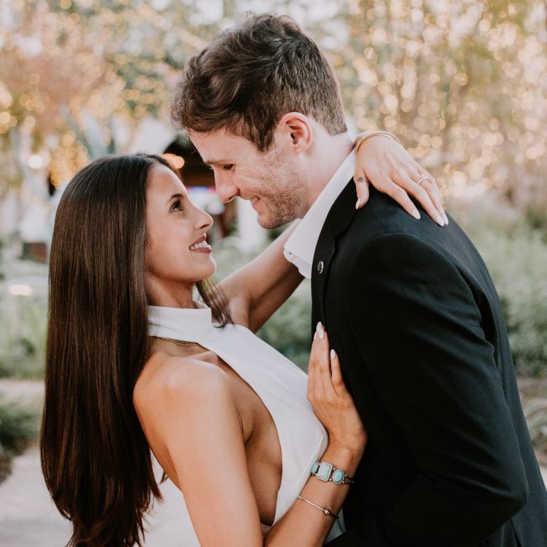 Couple walking past historic buildings during an engagement session at the Fort Worth Stockyards